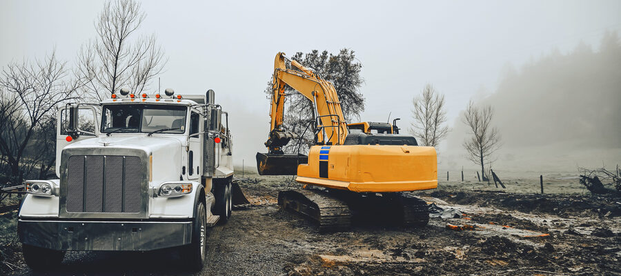 Large excavator loads ground onto a truck with large body