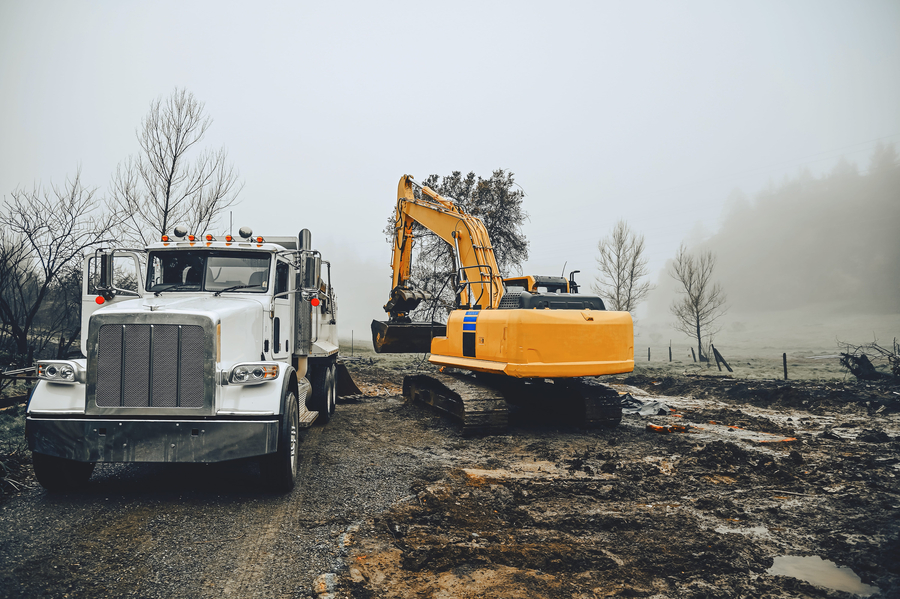 Large excavator loads ground onto a truck with large body