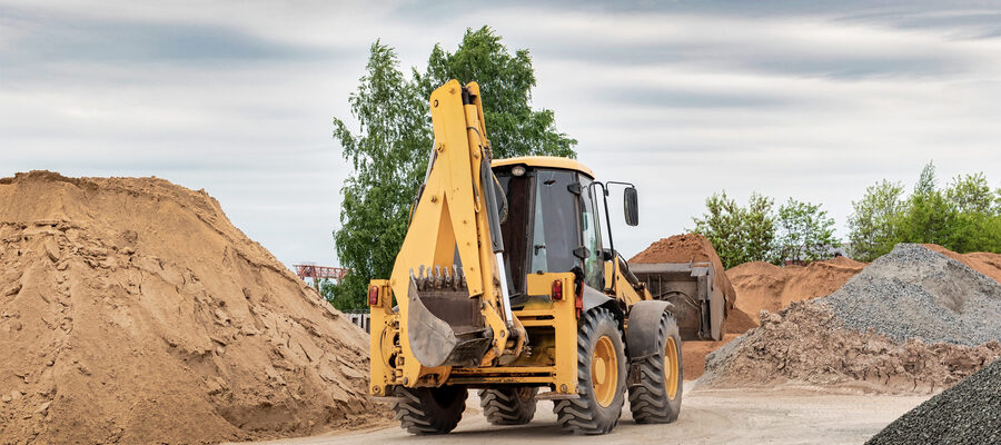 Powerful wheel loader or bulldozer at the construction site. Loader transport sand in a storage bucket. Powerful modern equipment for earthworks