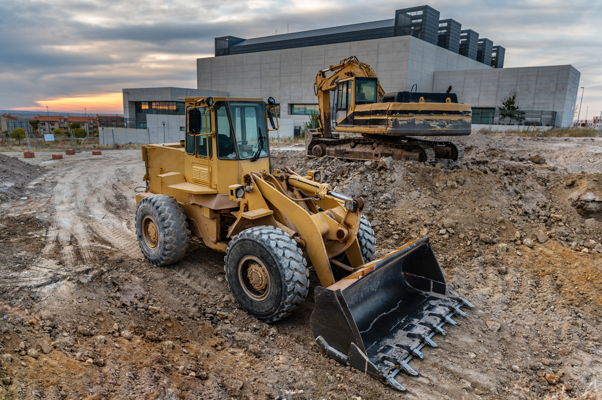 Two excavators at a construction site performing earthmoving